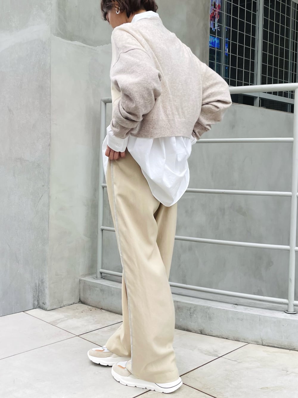 ベージュ系のニット/セーター、ベージュ系のその他パンツ、ホワイト系のシャツ/ブラウスを着用したレディースの秋コーディネートの2枚目の写真