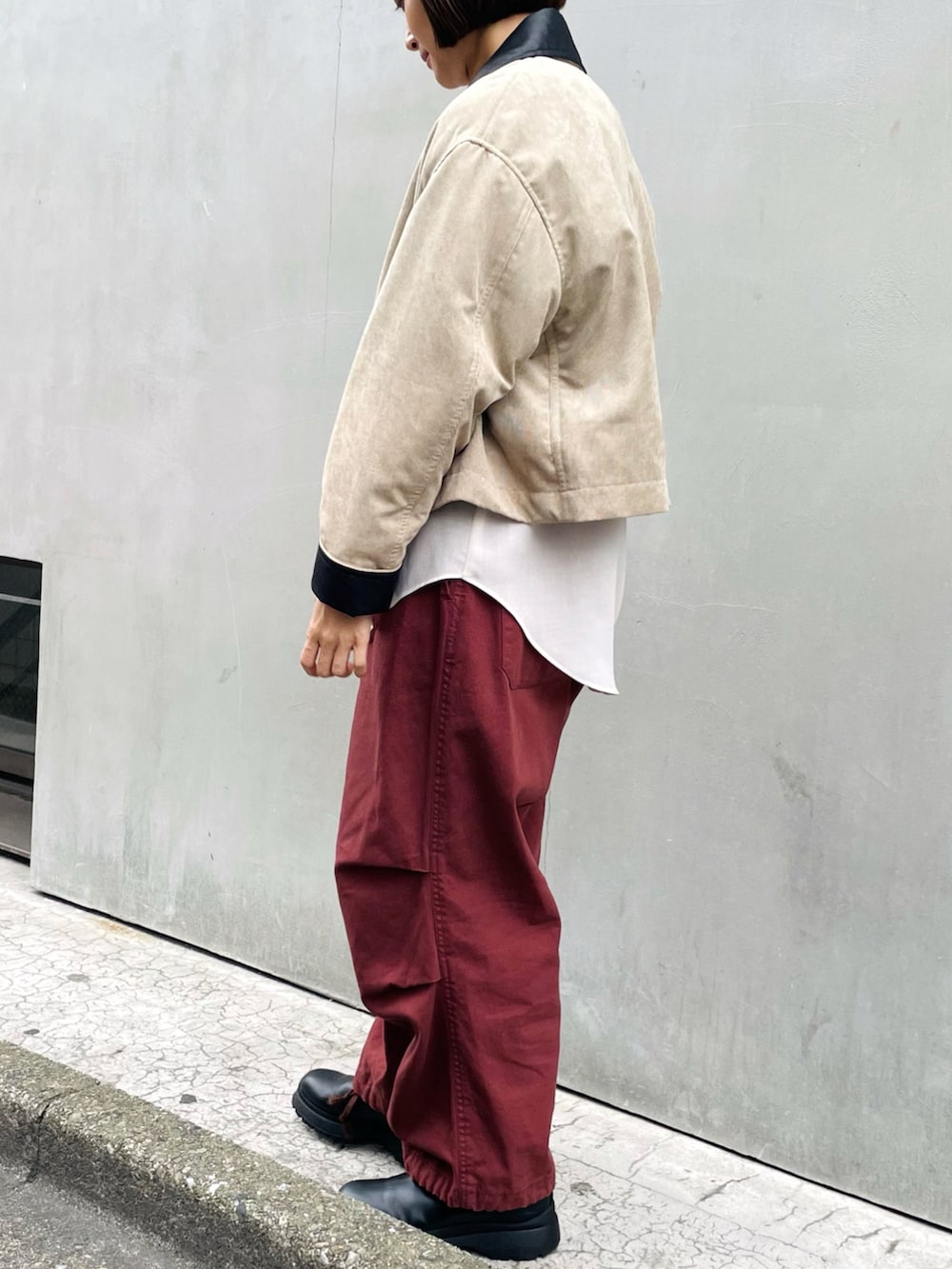 ホワイト系のシャツ/ブラウス、ベージュ系のカバーオール、ブラック系のブーツを着用したレディースの春コーディネートの2枚目の写真