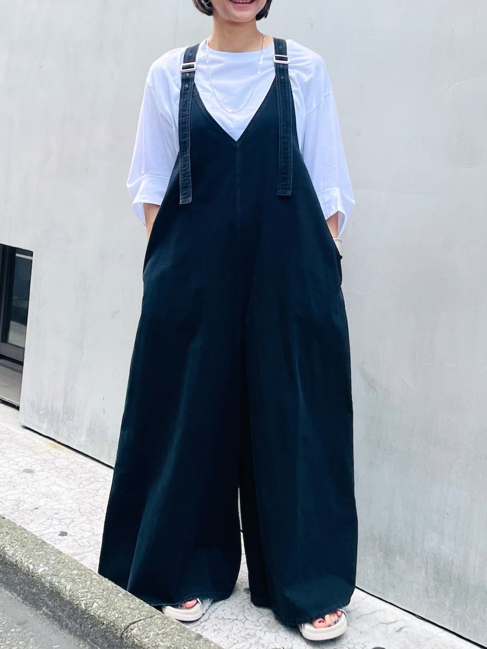 ブラック系のサロペット/オーバーオール、ホワイト系のTシャツ/カットソー、シルバー系のネックレスを着用したレディースの夏コーディネートの2枚目の写真