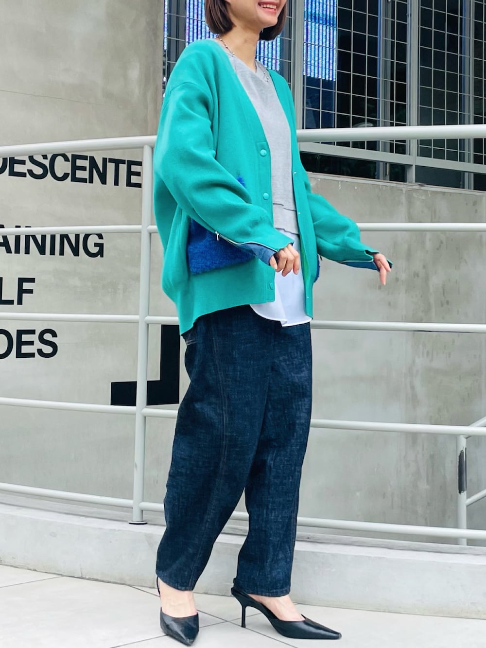 グリーン系のカーディガン/ボレロ、ブルー系のデニムパンツ、グレー系のTシャツ/カットソーを着用したレディースの秋コーディネートの2枚目の写真
