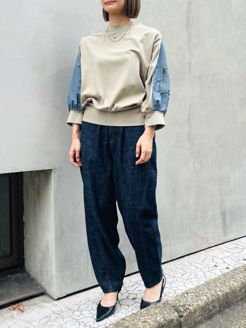 グリーン系のTシャツ/カットソー、ブルー系のデニムパンツ、ブラック系のパンプスを着用したレディースの秋コーディネートの2枚目の写真