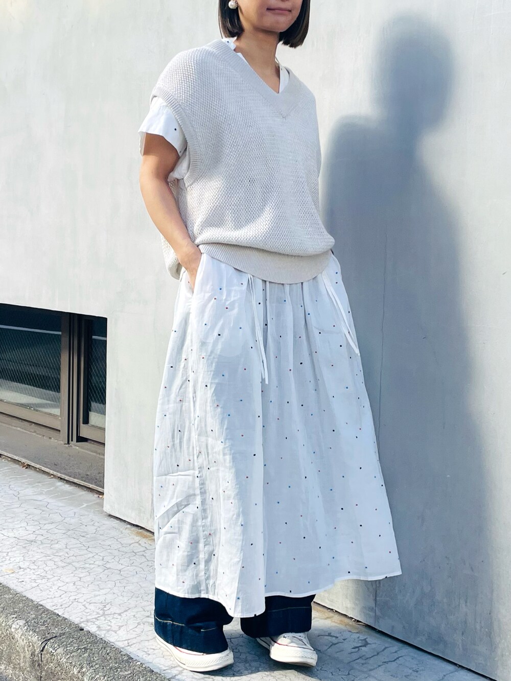 ホワイト系のTシャツ/カットソー、ホワイト系のワンピース、ブルー系のデニムパンツを着用したレディースの春コーディネートの2枚目の写真