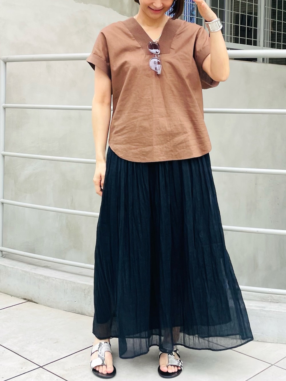 ブラウン系のシャツ/ブラウス、ブラック系のスカート、グレー系のサングラスを着用したレディースの夏コーディネートの2枚目の写真