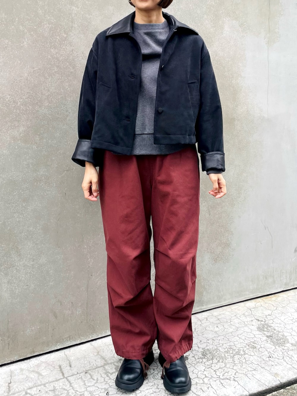 ブルー系のカバーオール、レッド系のその他パンツ、ブラック系のブーツを着用したレディースの冬コーディネートの2枚目の写真