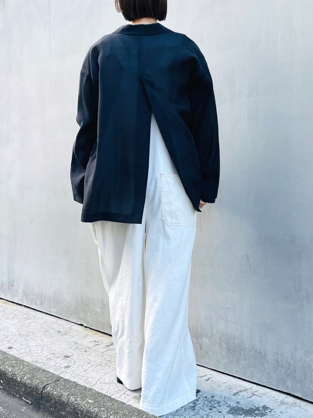 ブラック系のテーラードジャケット、ホワイト系のサロペット/オーバーオール、ピンク系のタンクトップを着用したレディースの春コーディネートの2枚目の写真