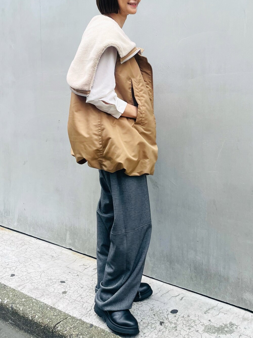 イエロー系のその他アウター、グレー系のその他パンツ、ホワイト系のシャツ/ブラウスを着用したレディースの秋コーディネートの2枚目の写真