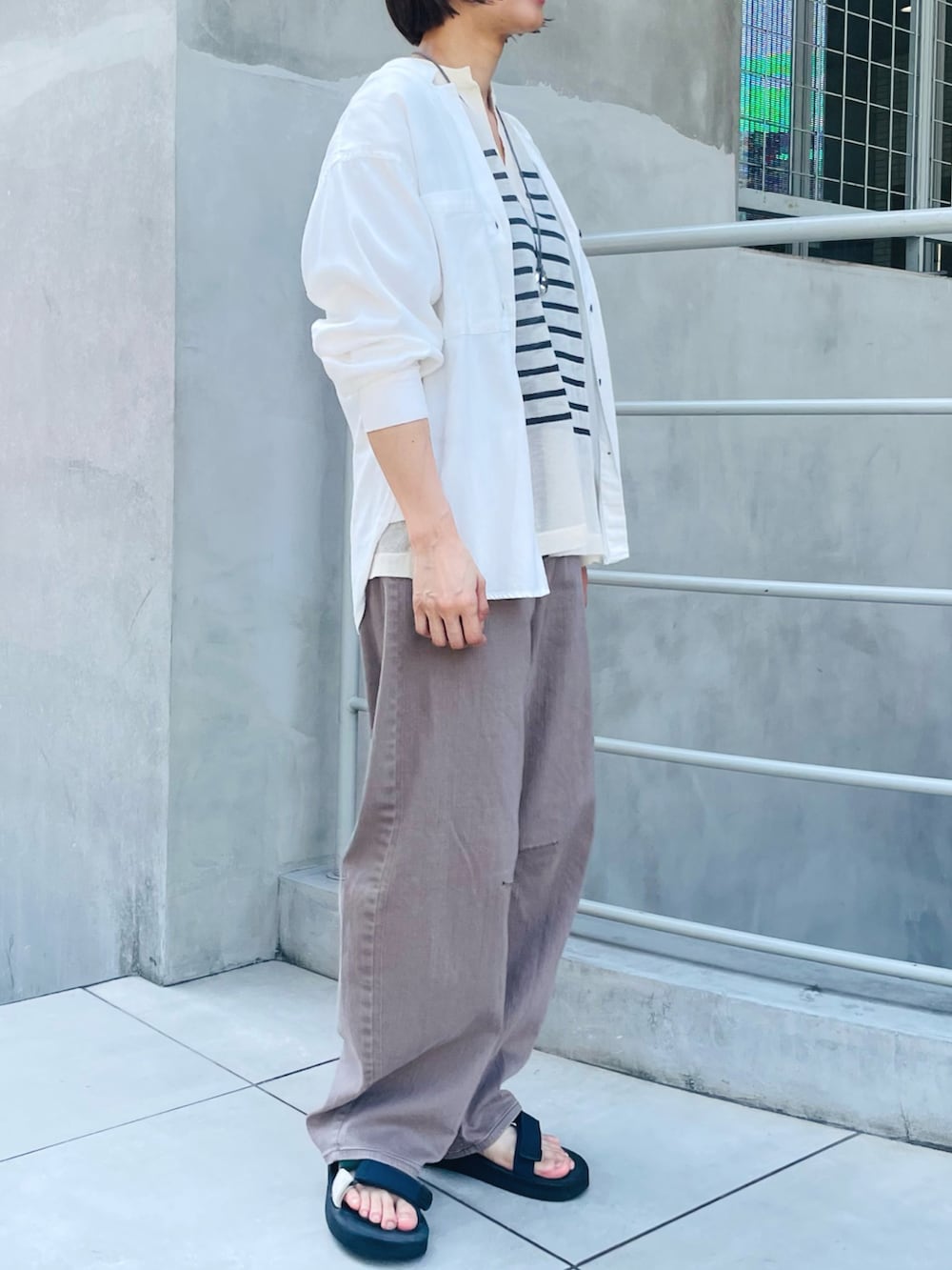 ホワイト系のシャツ/ブラウス、ブラウン系のデニムパンツ、ベージュ系のニット/セーターを着用したレディースの秋コーディネートの2枚目の写真