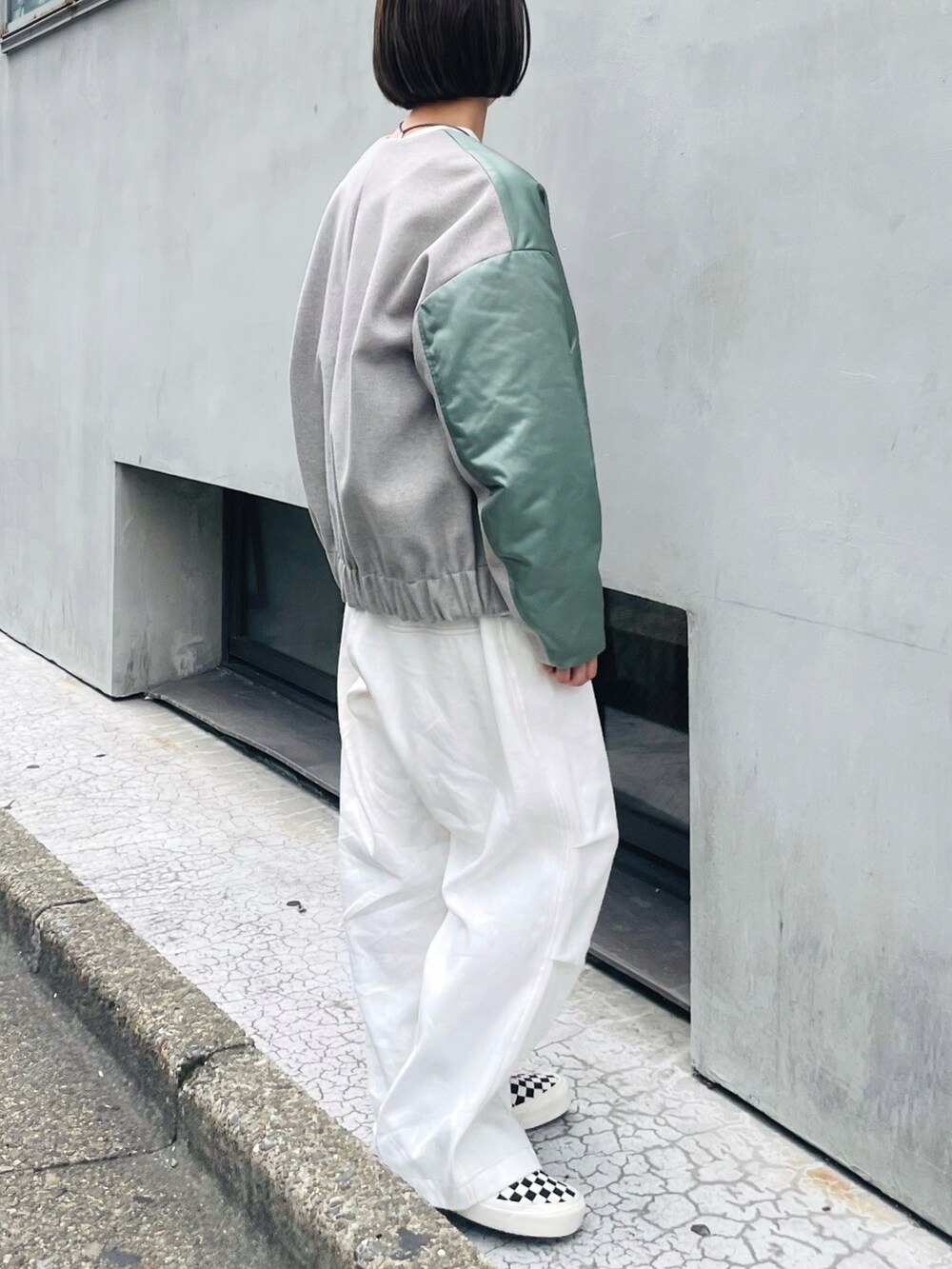 グリーン系のブルゾン、ホワイト系のその他パンツ、ホワイト系のスニーカーを着用したレディースの秋コーディネートの2枚目の写真
