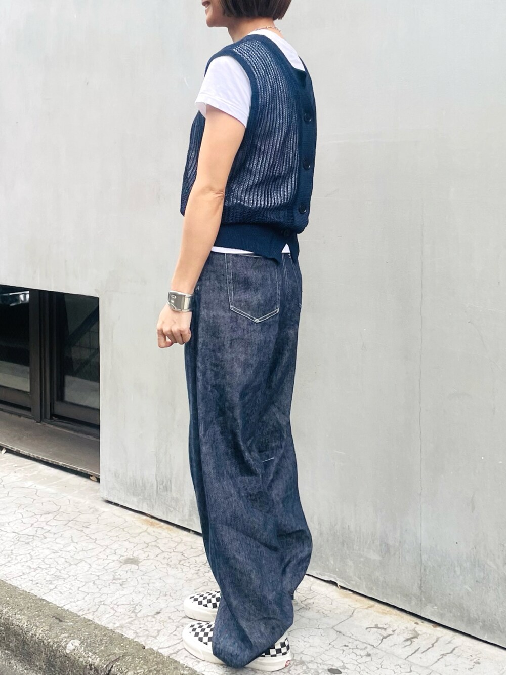 ブルー系のベスト、ブルー系のデニムパンツ、ホワイト系のTシャツ/カットソーを着用したレディースの夏コーディネートの2枚目の写真