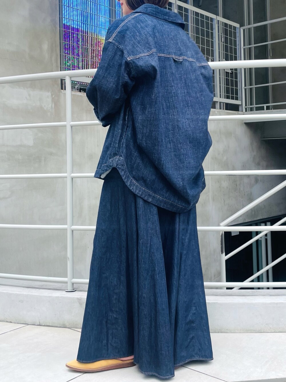 ブルー系のシャツ/ブラウス、グレー系のTシャツ/カットソー、ブルー系のデニムスカートを着用したレディースの夏コーディネートの2枚目の写真