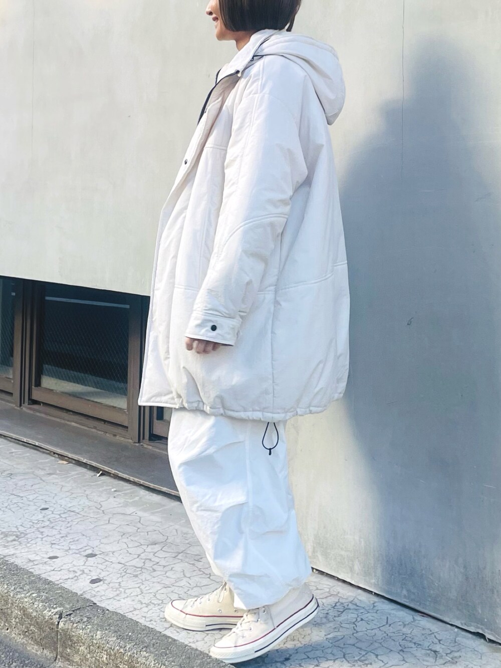 ホワイト系のその他アウター、ホワイト系のその他パンツ、ホワイト系のスニーカーを着用したレディースの冬コーディネートの2枚目の写真
