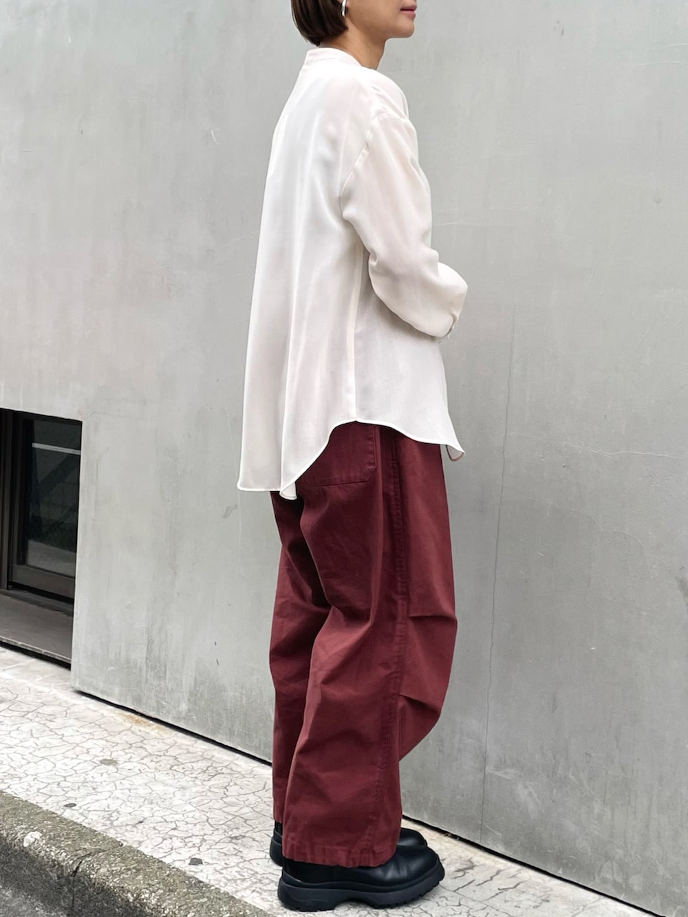 ホワイト系のシャツ/ブラウス、レッド系のその他パンツ、ブラック系のブーツを着用したレディースの春コーディネートの2枚目の写真
