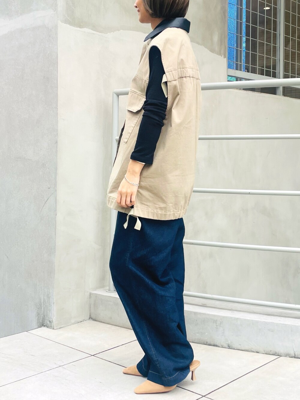 ベージュ系のブルゾン、ブルー系のデニムパンツ、ブラック系のTシャツ/カットソーを着用したレディースの冬コーディネートの2枚目の写真