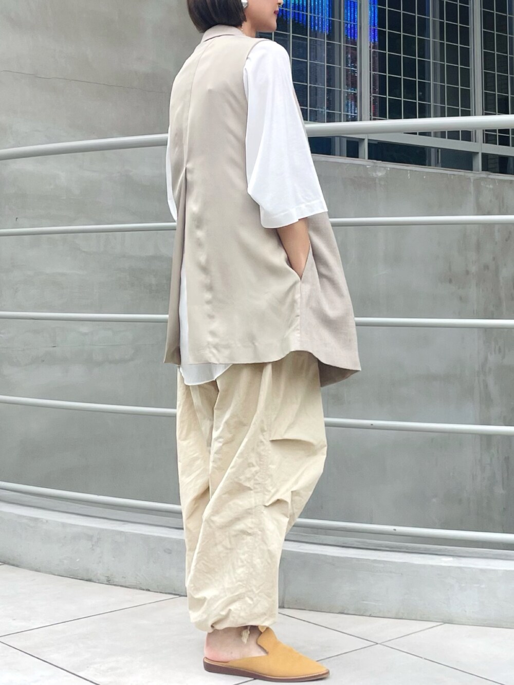 ベージュ系のベスト、ベージュ系のカーゴパンツ、ホワイト系のTシャツ/カットソーを着用したレディースの秋コーディネートの2枚目の写真