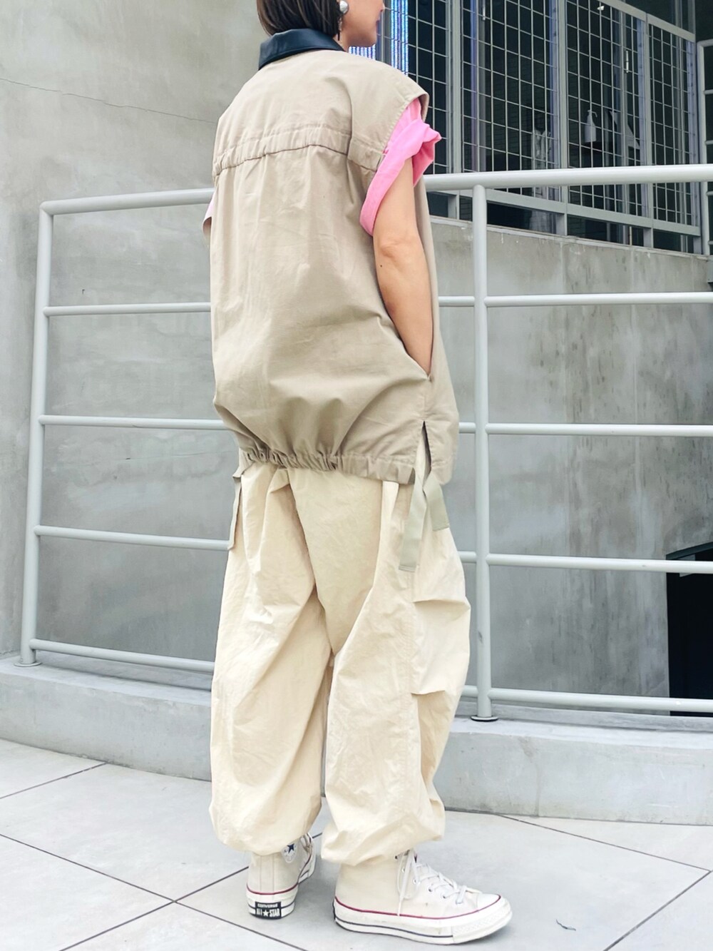 ベージュ系のブルゾン、ベージュ系のカーゴパンツ、ピンク系のTシャツ/カットソーを着用したレディースの秋コーディネートの2枚目の写真