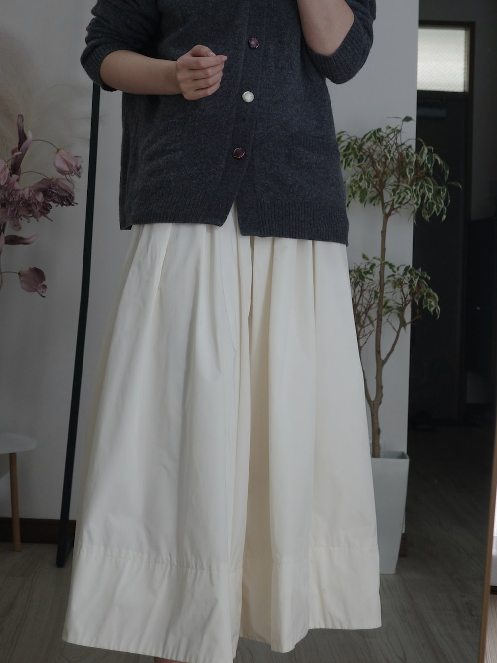 ホワイト系のスカート、グレー系のカーディガン/ボレロを着用したレディースの冬コーディネートの2枚目の写真