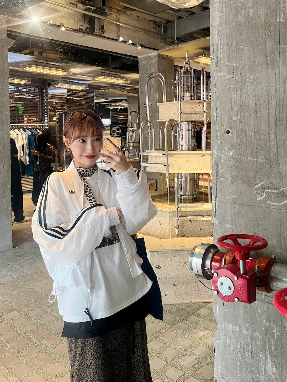 ホワイト系のTシャツ/カットソー、ブラウン系のスカート、ブルー系のトートバッグを着用したレディースの秋コーディネートの3枚目の写真