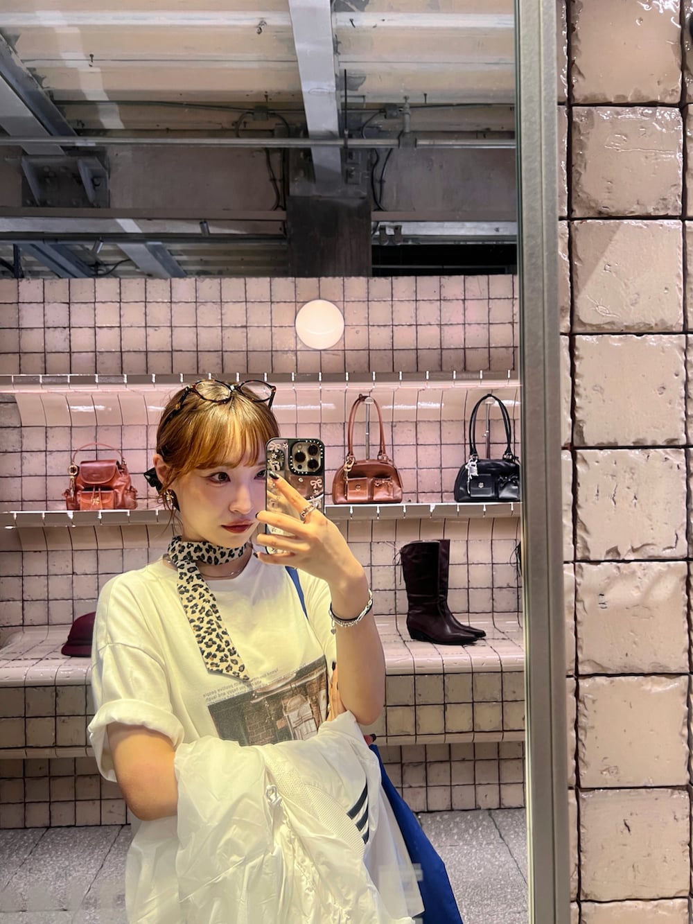 ホワイト系のTシャツ/カットソー、ブラウン系のスカート、ブルー系のトートバッグを着用したレディースの秋コーディネートの5枚目の写真