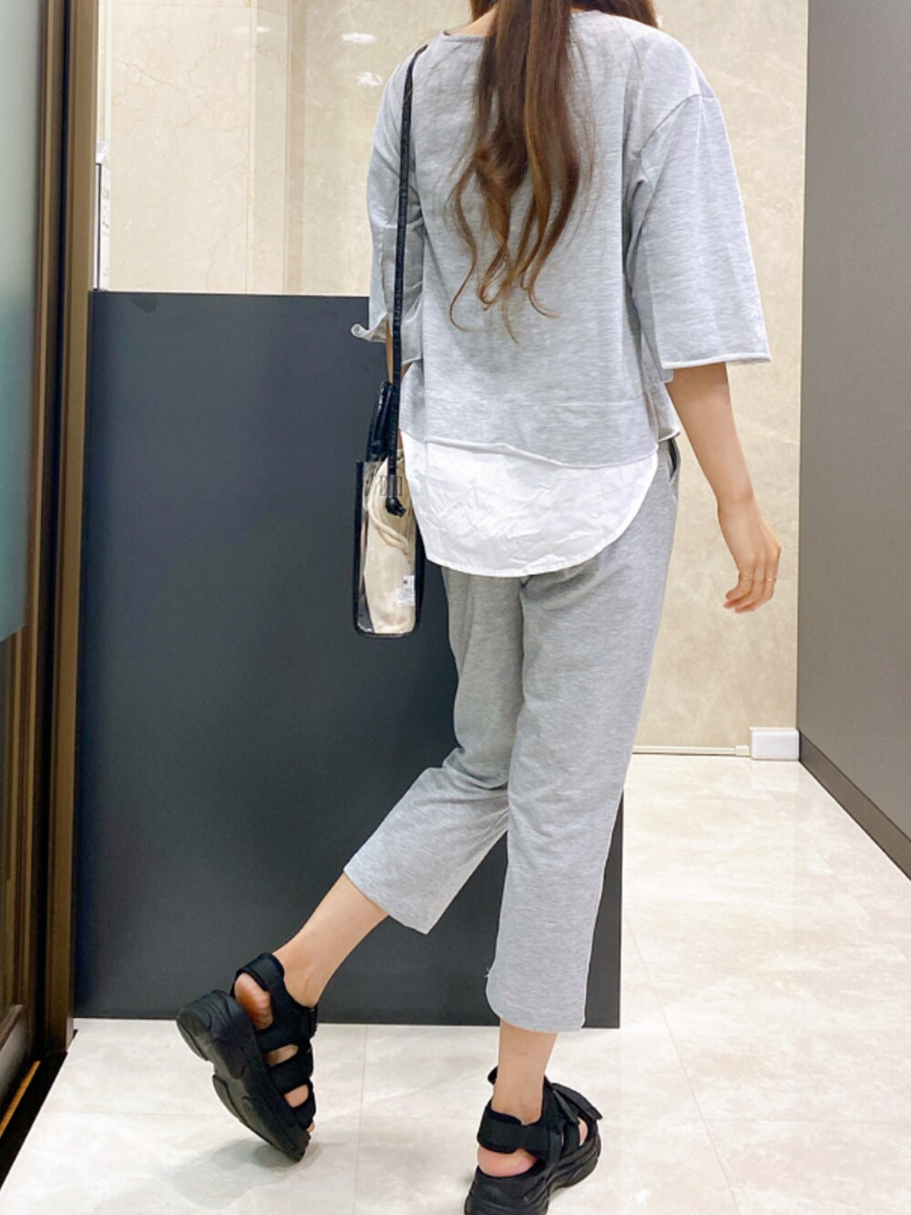 ブラック系のサンダル、グレー系のセットアップ、ブラック系のショルダーバッグを着用したレディースの夏コーディネートの3枚目の写真