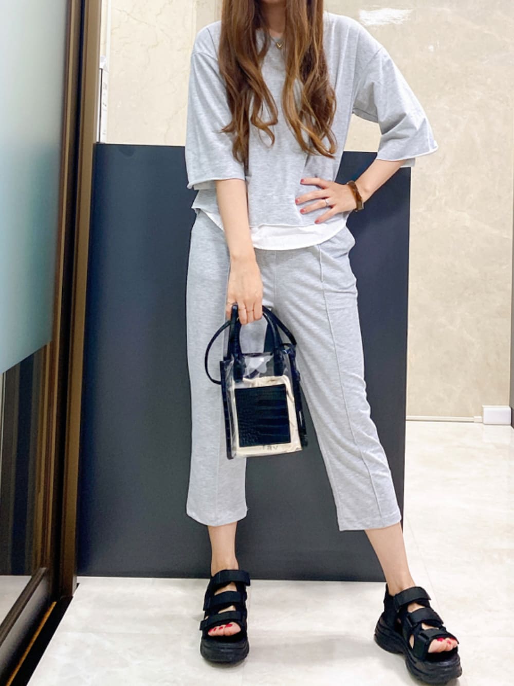 ブラック系のサンダル、グレー系のセットアップ、ブラック系のショルダーバッグを着用したレディースの夏コーディネートの4枚目の写真