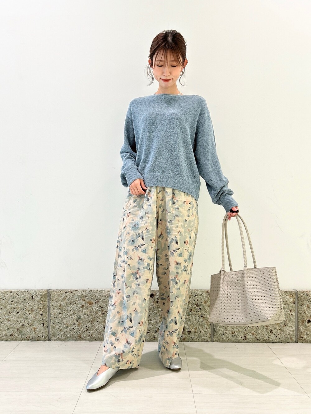 ブルー系のニット/セーター、ホワイト系のトートバッグ、シルバー系のパンプスを着用したレディースの春コーディネートの4枚目の写真