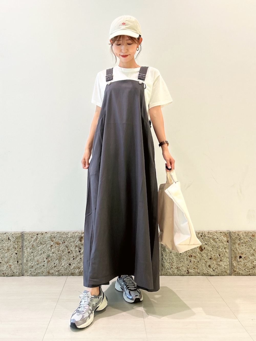 ホワイト系のTシャツ/カットソー、シルバー系のスニーカー、ベージュ系のショルダーバッグを着用したレディースの夏コーディネートの3枚目の写真