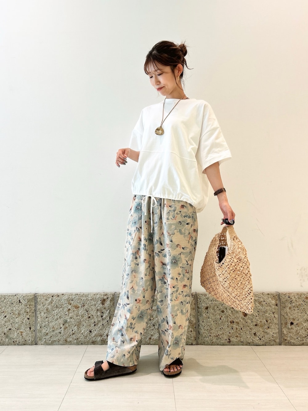 ホワイト系のTシャツ/カットソー、ベージュ系のハンドバッグ、ブルー系のその他パンツを着用したレディースの夏コーディネートの2枚目の写真