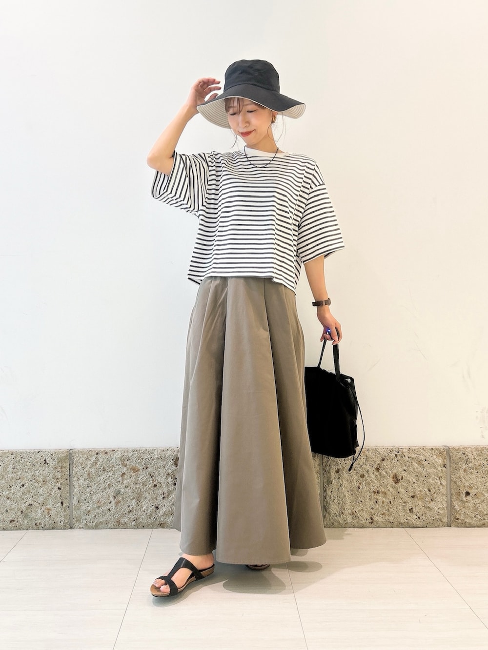 ホワイト系のTシャツ/カットソー、グリーン系のスカート、ブラック系のショルダーバッグを着用したレディースの夏コーディネートの2枚目の写真