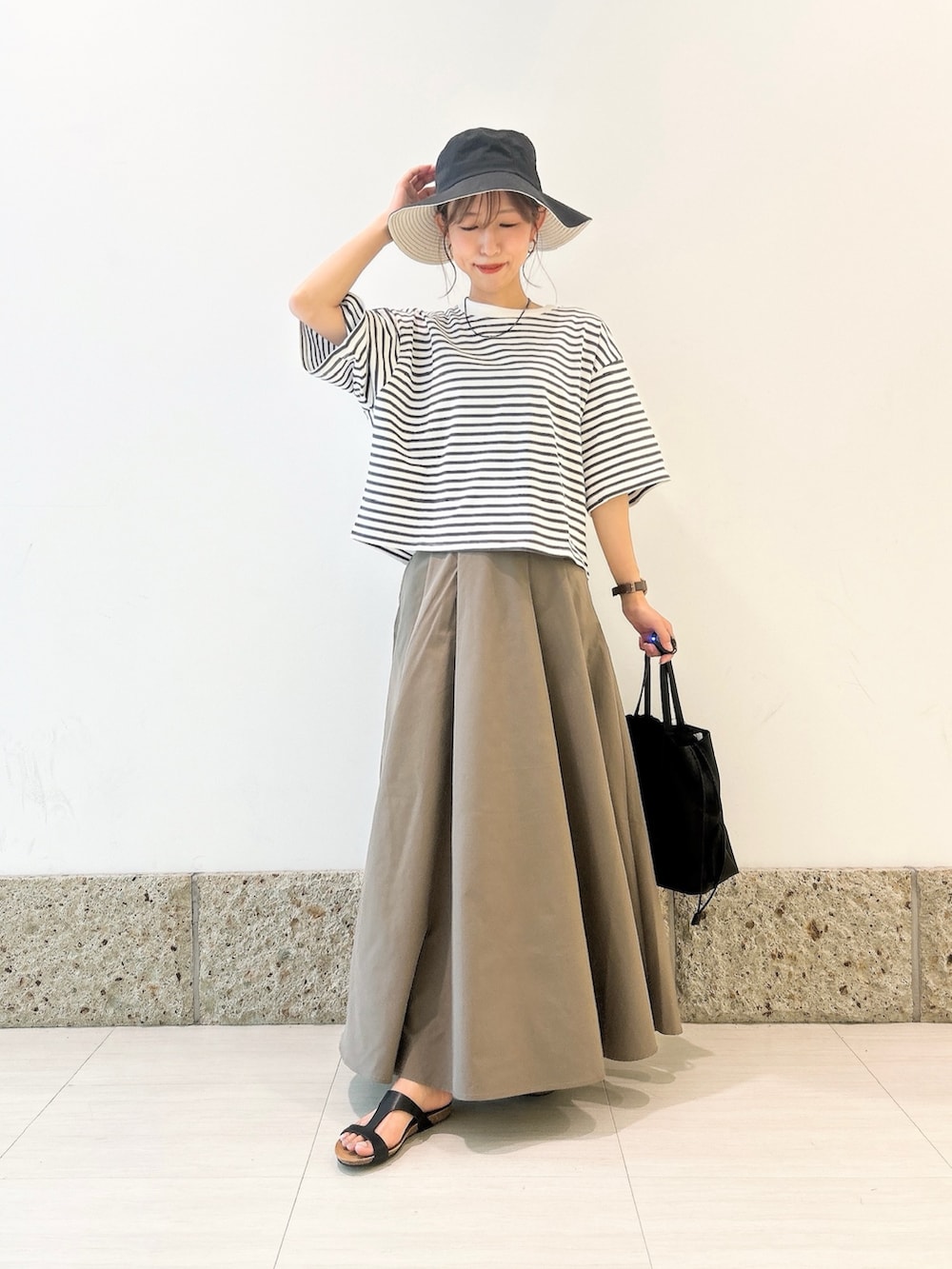 ホワイト系のTシャツ/カットソー、グリーン系のスカート、ブラック系のショルダーバッグを着用したレディースの夏コーディネートの3枚目の写真