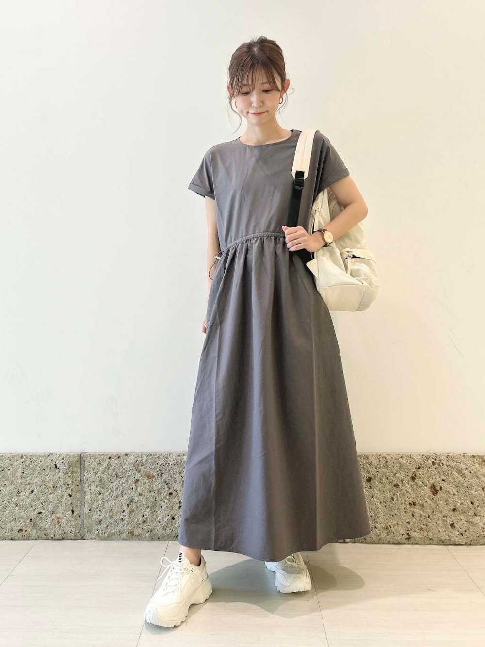 ホワイト系のバックパック/リュック、ホワイト系のスニーカー、グレー系のワンピースを着用したレディースの夏コーディネートの2枚目の写真