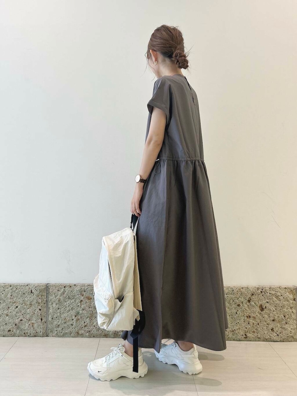 ホワイト系のバックパック/リュック、ホワイト系のスニーカー、グレー系のワンピースを着用したレディースの夏コーディネートの3枚目の写真