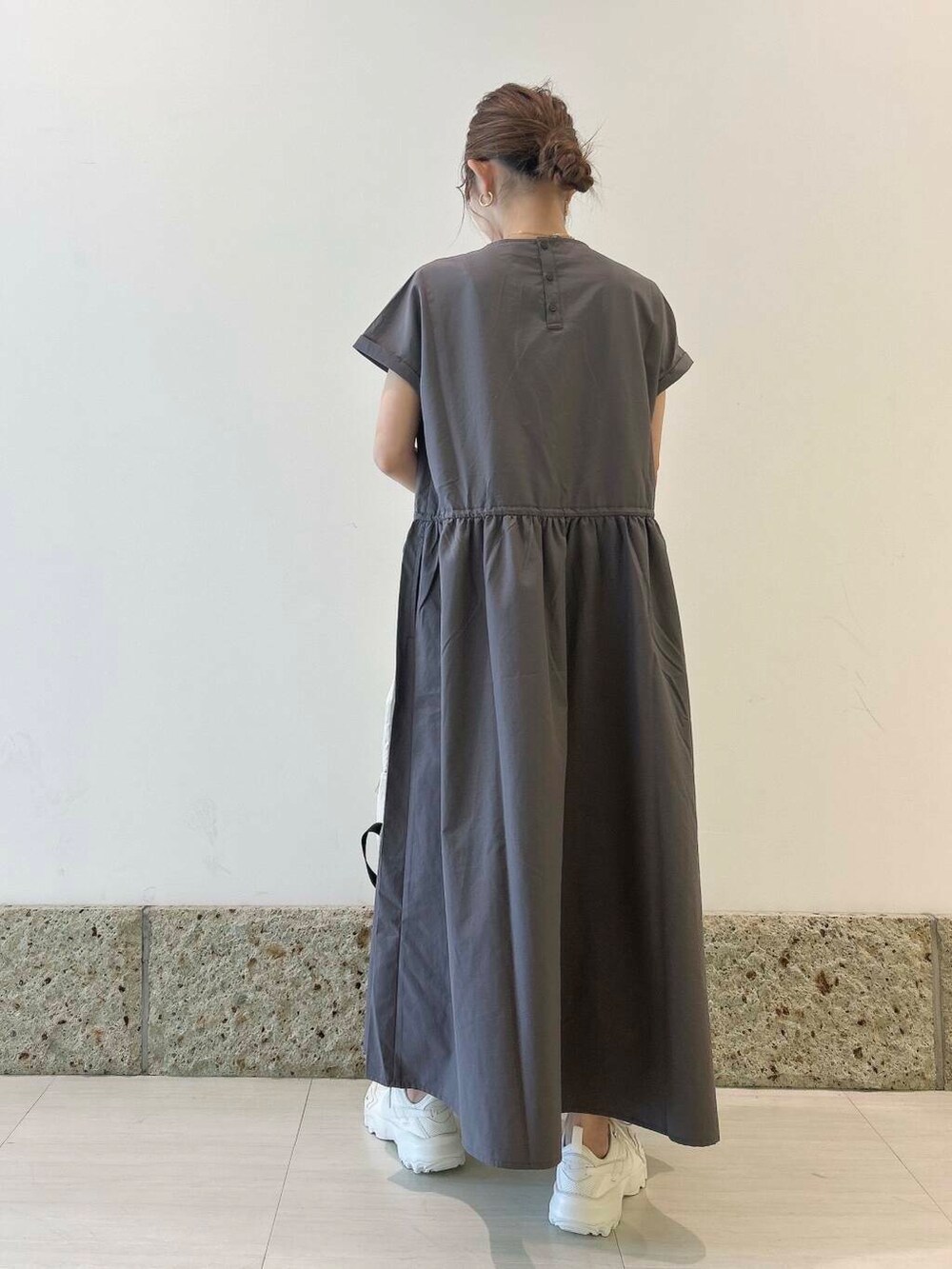 ホワイト系のバックパック/リュック、ホワイト系のスニーカー、グレー系のワンピースを着用したレディースの夏コーディネートの4枚目の写真