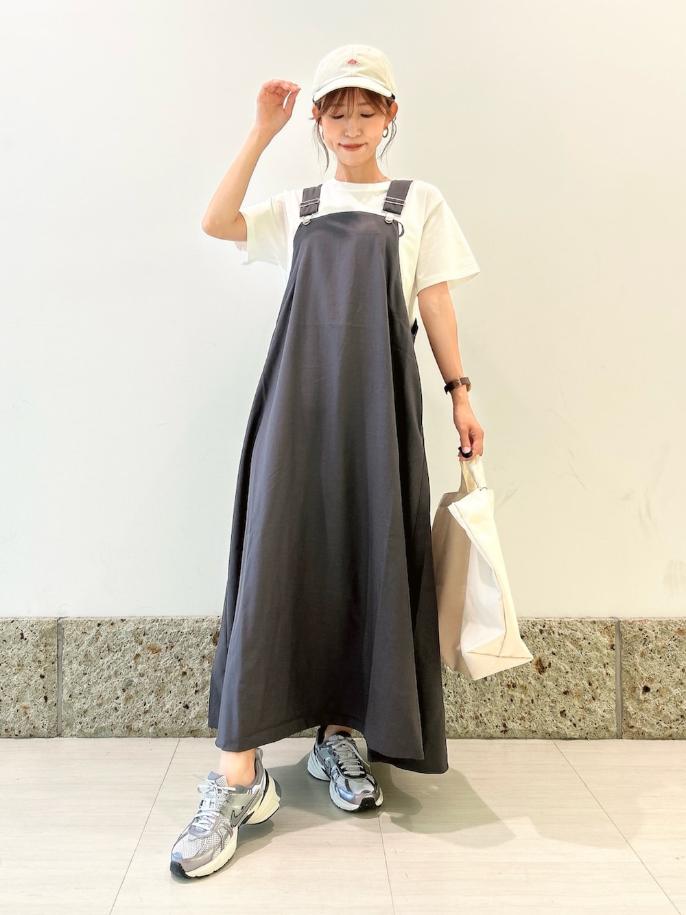 ホワイト系のTシャツ/カットソー、シルバー系のスニーカー、ベージュ系のショルダーバッグを着用したレディースの夏コーディネートの2枚目の写真