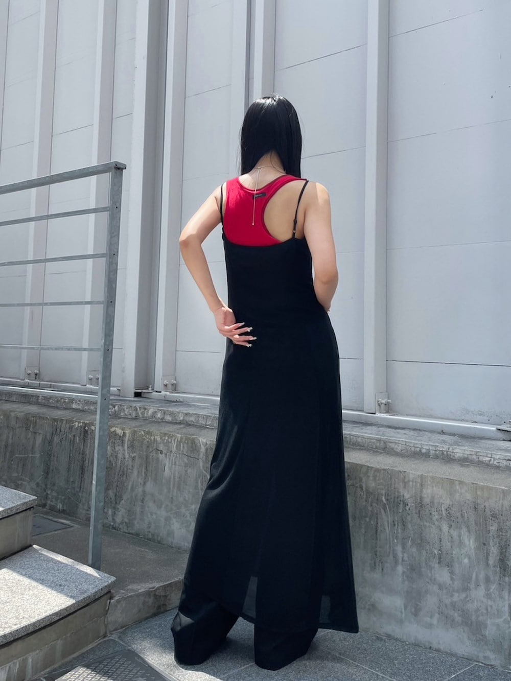 ホワイト系のワンピース、ブラック系のスラックス、レッド系のタンクトップを着用したレディースの夏コーディネートの3枚目の写真