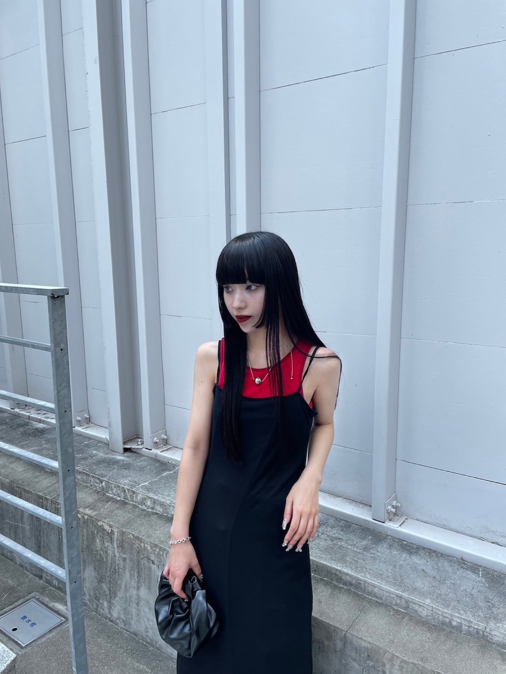 レッド系のタンクトップ、ホワイト系のワンピースを着用したレディースの夏コーディネートの2枚目の写真