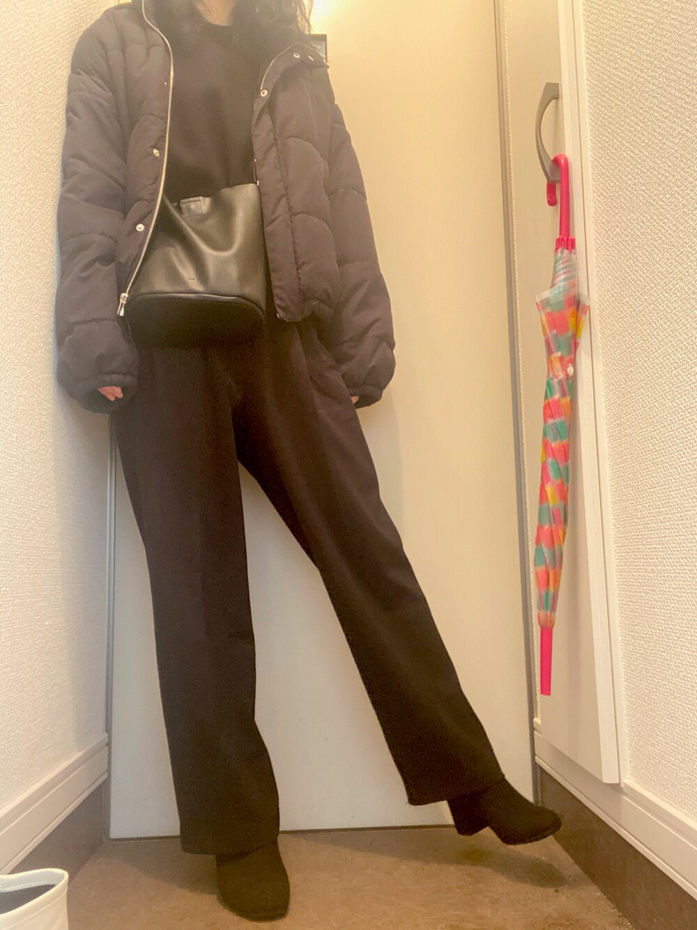 ブラック系のダウンジャケット/コート、ブラック系のその他パンツ、ブラック系のブーツを着用したレディースの冬コーディネートの2枚目の写真