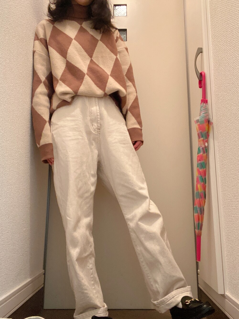 ブラック系のダウンジャケット/コート、ホワイト系のその他パンツ、ブラック系のシューズを着用したレディースの冬コーディネートの2枚目の写真