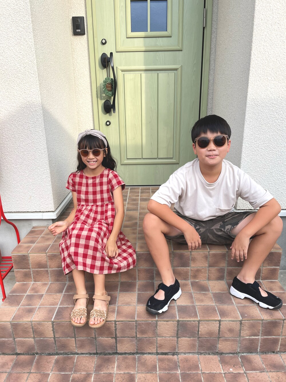 グリーン系のその他パンツ、レッド系のワンピース、ブラウン系のサンダルを着用したキッズの夏コーディネートの2枚目の写真