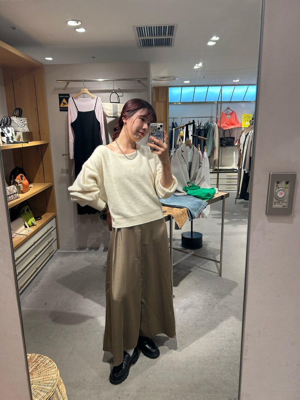 ホワイト系のニット/セーター、ブラウン系のワンピースを着用したレディースの秋コーディネートの3枚目の写真