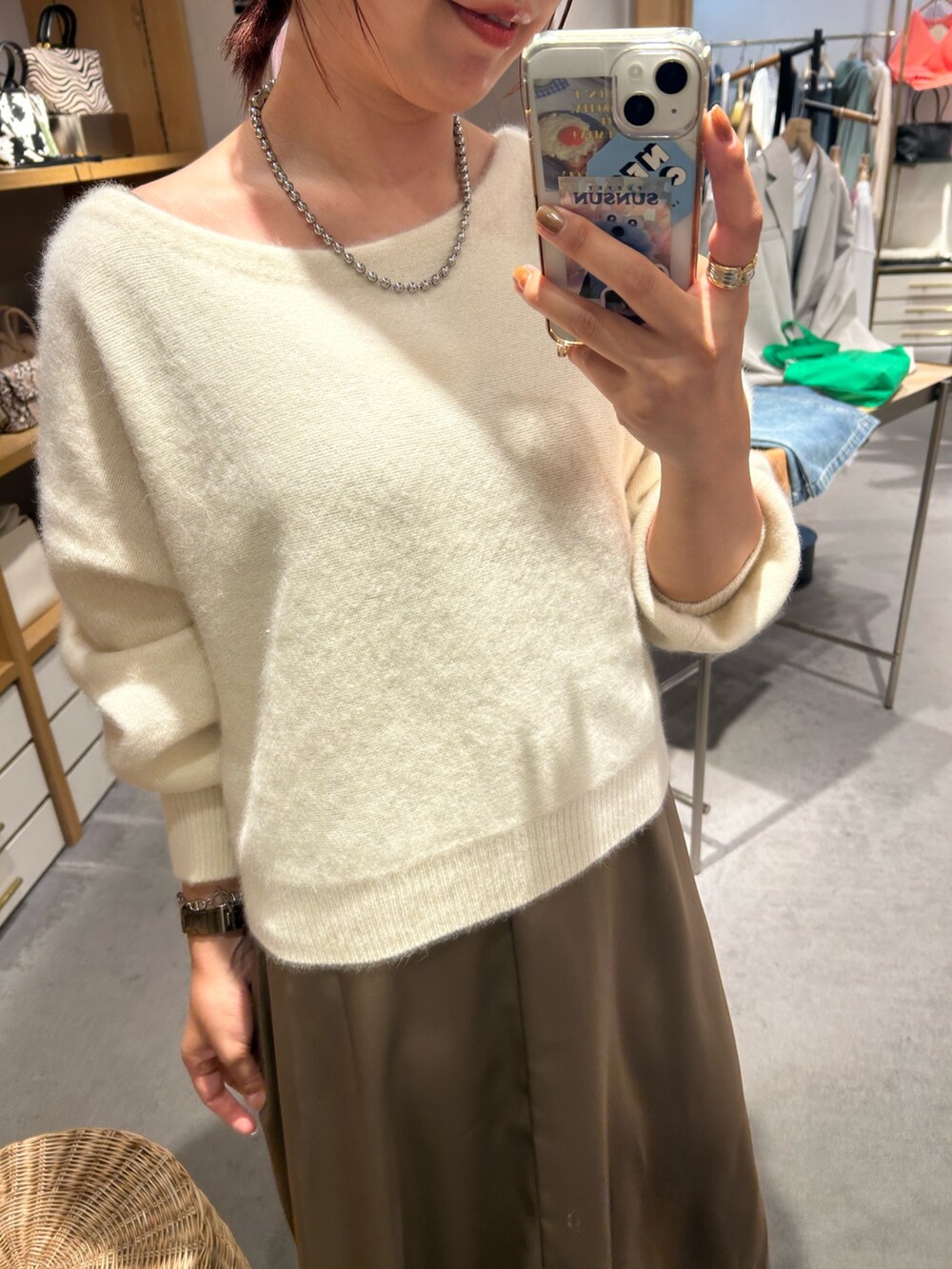 ホワイト系のニット/セーター、ブラウン系のワンピースを着用したレディースの秋コーディネートの2枚目の写真