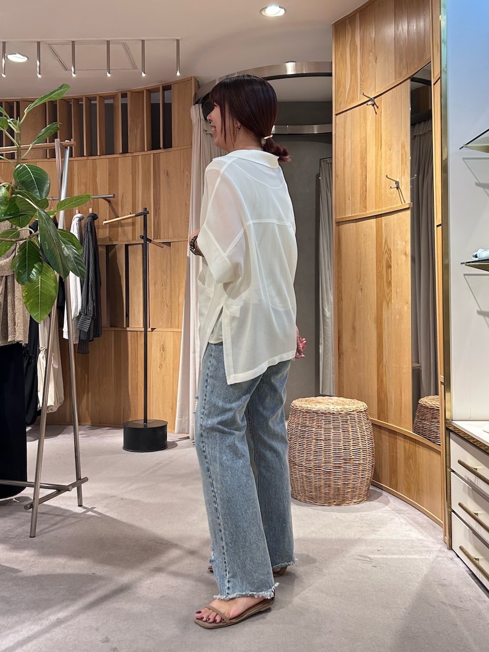 ブルー系のデニムパンツ、ホワイト系のテーラードジャケット、ホワイト系のタンクトップを着用したレディースの夏コーディネートの2枚目の写真
