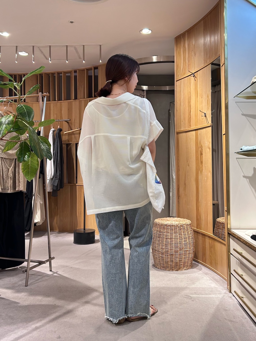 ブルー系のデニムパンツ、ホワイト系のテーラードジャケット、ホワイト系のタンクトップを着用したレディースの夏コーディネートの3枚目の写真