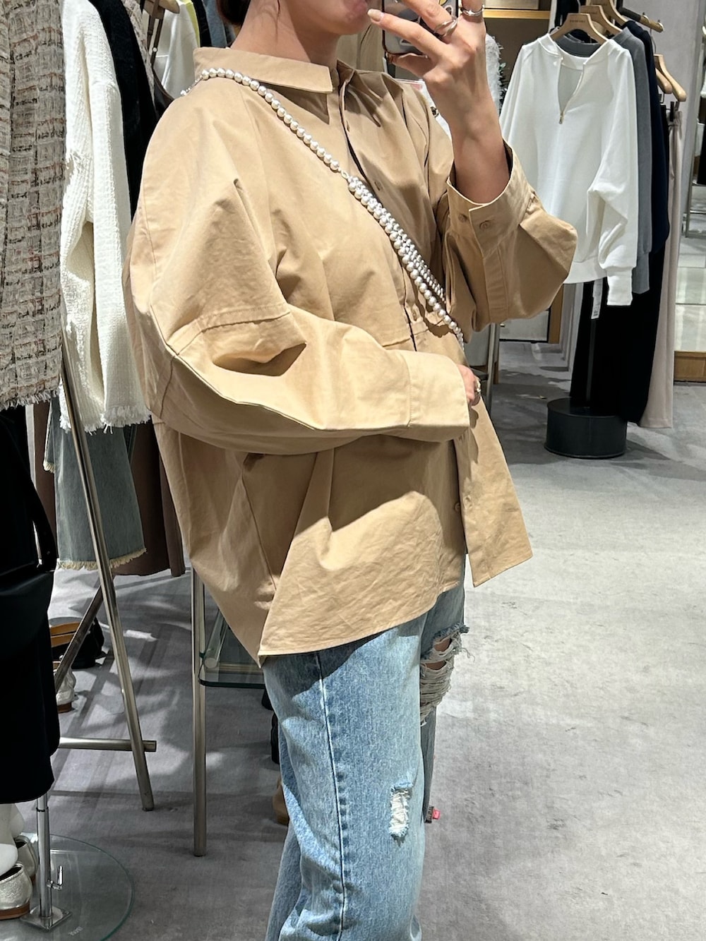 ベージュ系のシャツ/ブラウス、ブルー系のデニムパンツ、ゴールド系のパンプスを着用したレディースの冬コーディネートの3枚目の写真