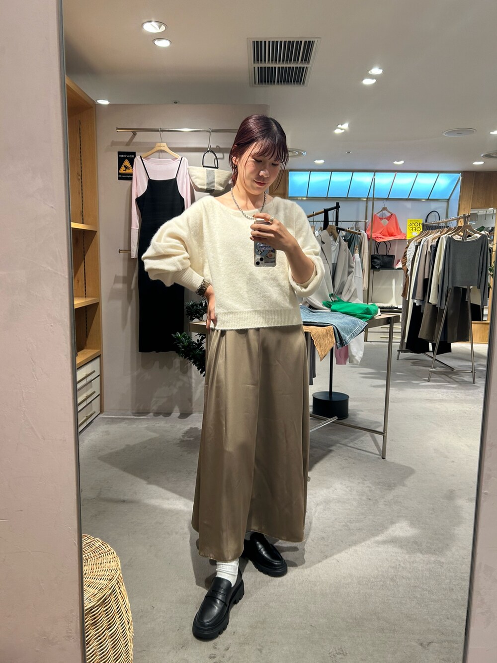 ホワイト系のニット/セーター、ブラウン系のワンピースを着用したレディースの秋コーディネートの4枚目の写真