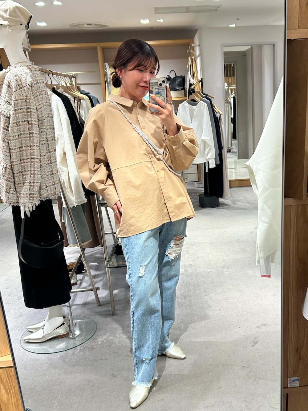 ベージュ系のシャツ/ブラウス、ブルー系のデニムパンツ、ゴールド系のパンプスを着用したレディースの冬コーディネートの2枚目の写真