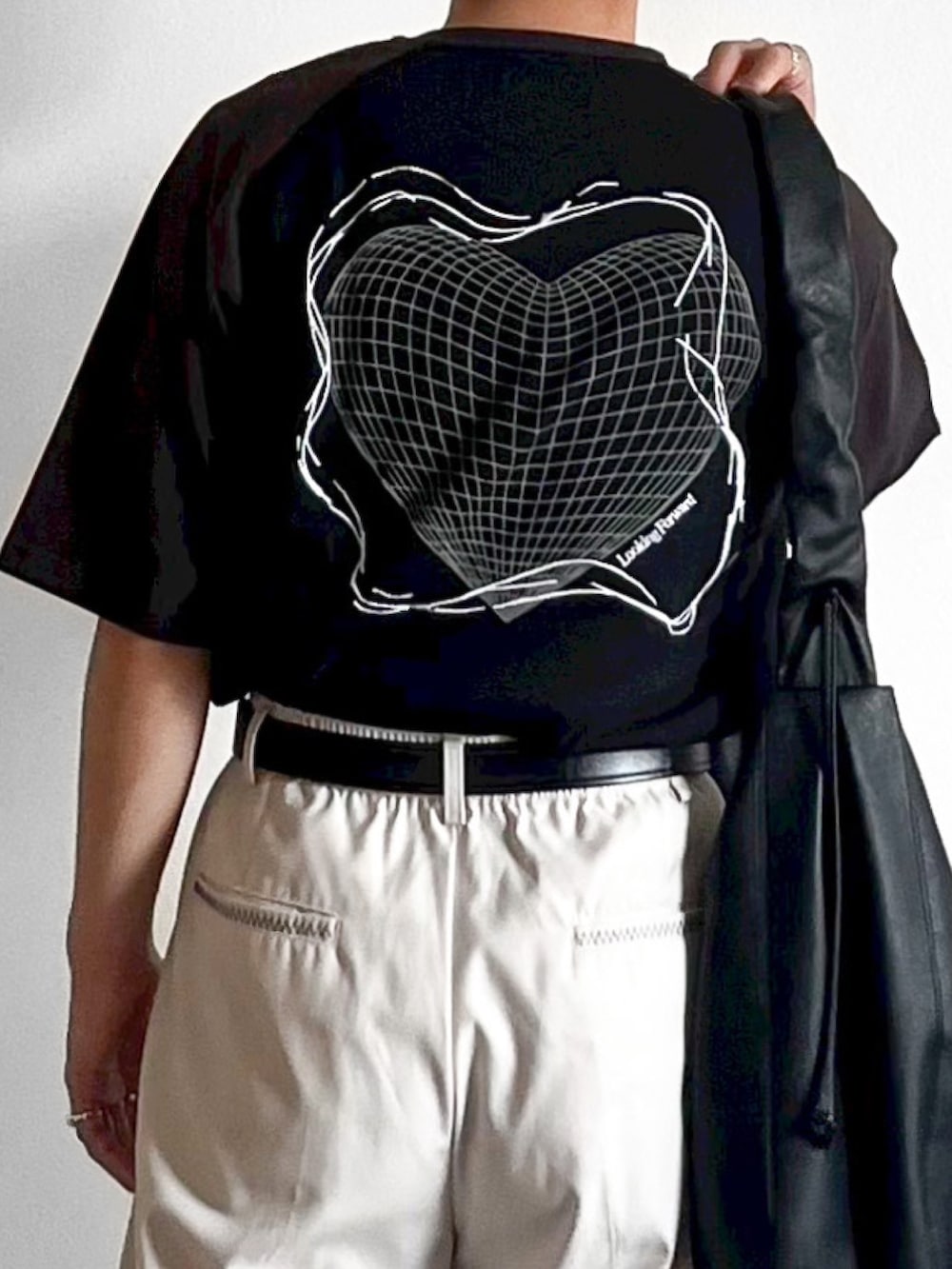 ブラック系のTシャツ/カットソー、グレー系のスラックス、ブラック系のショルダーバッグを着用したメンズの夏コーディネートの2枚目の写真