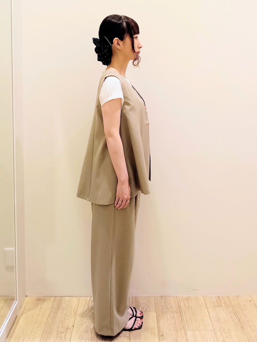 ブラウン系のベスト、ブラウン系のその他パンツ、レッド系のボストンバッグを着用したレディースの夏コーディネートの2枚目の写真