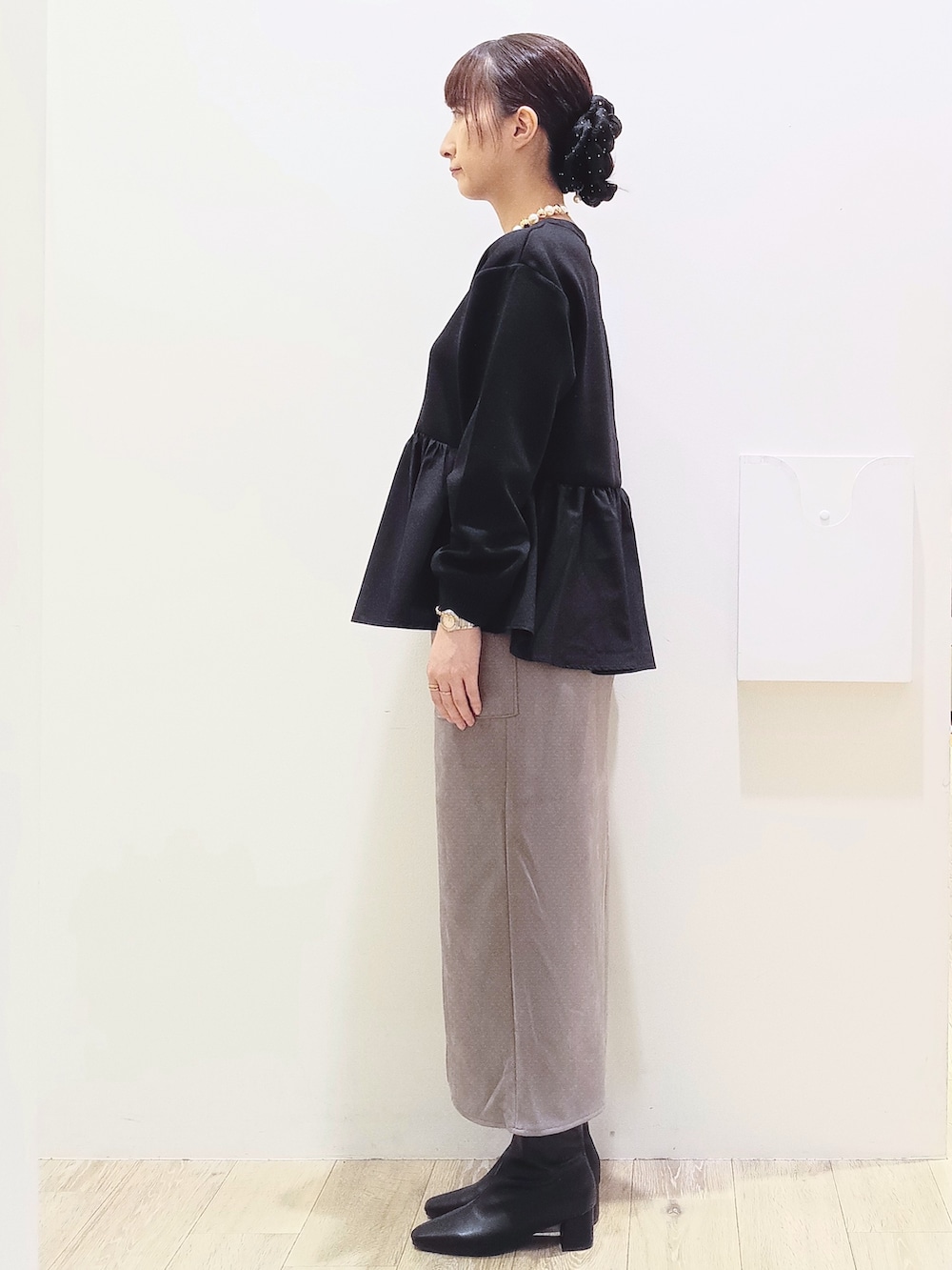 ブラック系のTシャツ/カットソー、ブラウン系のスカート、ブラック系のトートバッグを着用したレディースの秋コーディネートの4枚目の写真