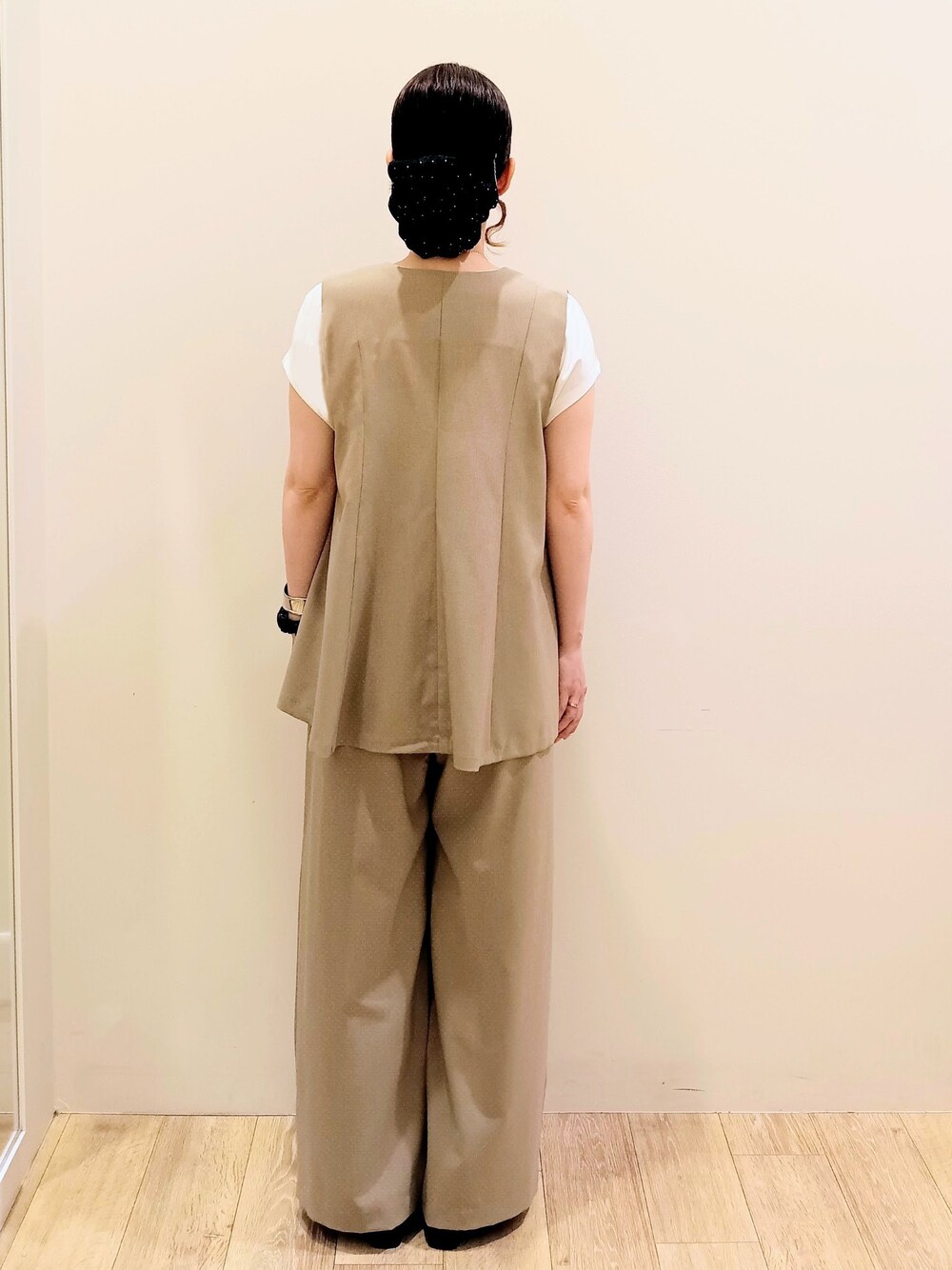 ブラウン系のベスト、ブラウン系のその他パンツ、レッド系のボストンバッグを着用したレディースの夏コーディネートの3枚目の写真