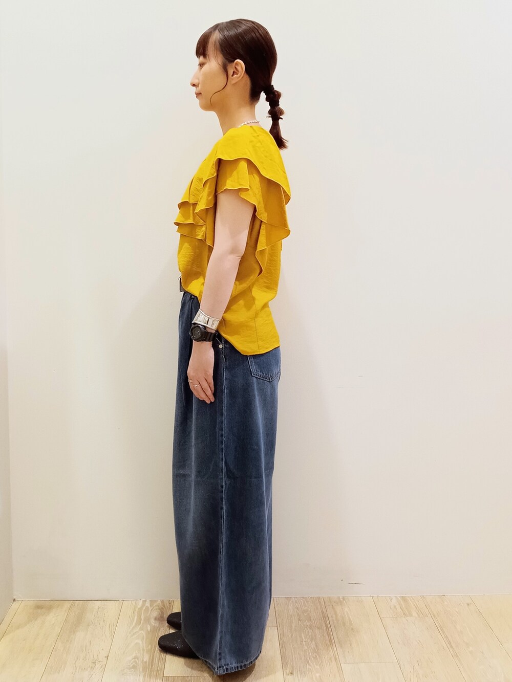 イエロー系のシャツ/ブラウス、ブルー系のデニムパンツ、ブラック系のショルダーバッグを着用したレディースの夏コーディネートの3枚目の写真